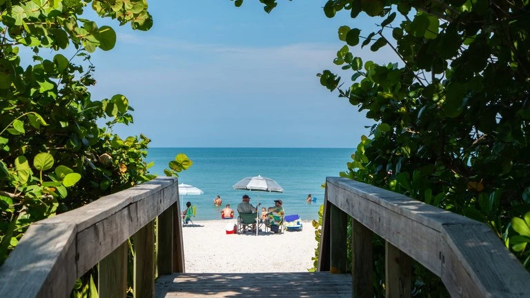 Couple Sitting on the Beach Under Umbrella